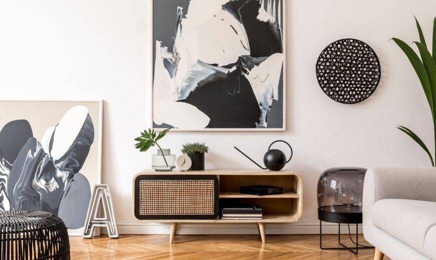A large black and white piece of abstract art above a small console table.