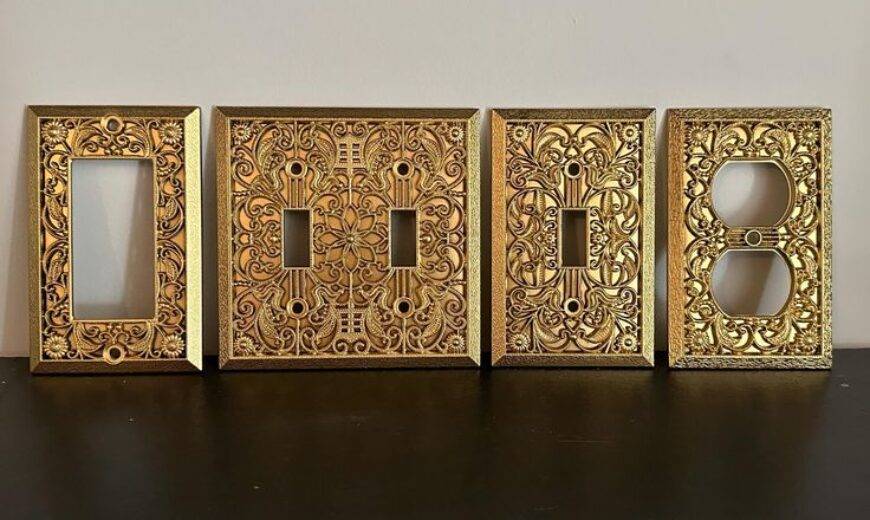 An assortment of gold light switch covers with intricate embossed patterns.