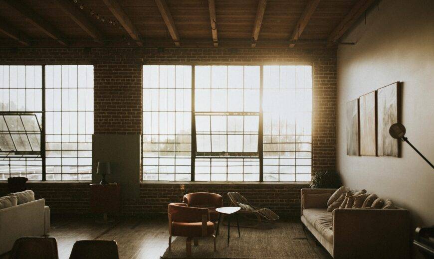 Large industrial windows letting sunlight into a minimalist, modern room.