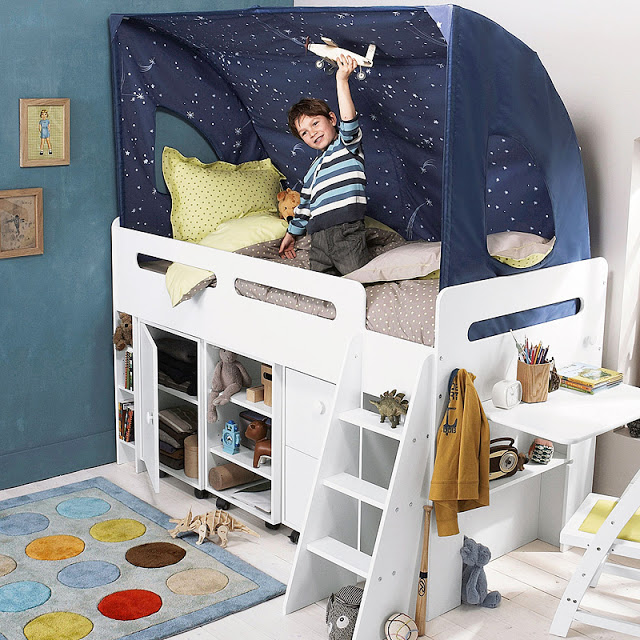 White bed with storage underneath, and a child is playing with an airplane inside a star-themed canopy.