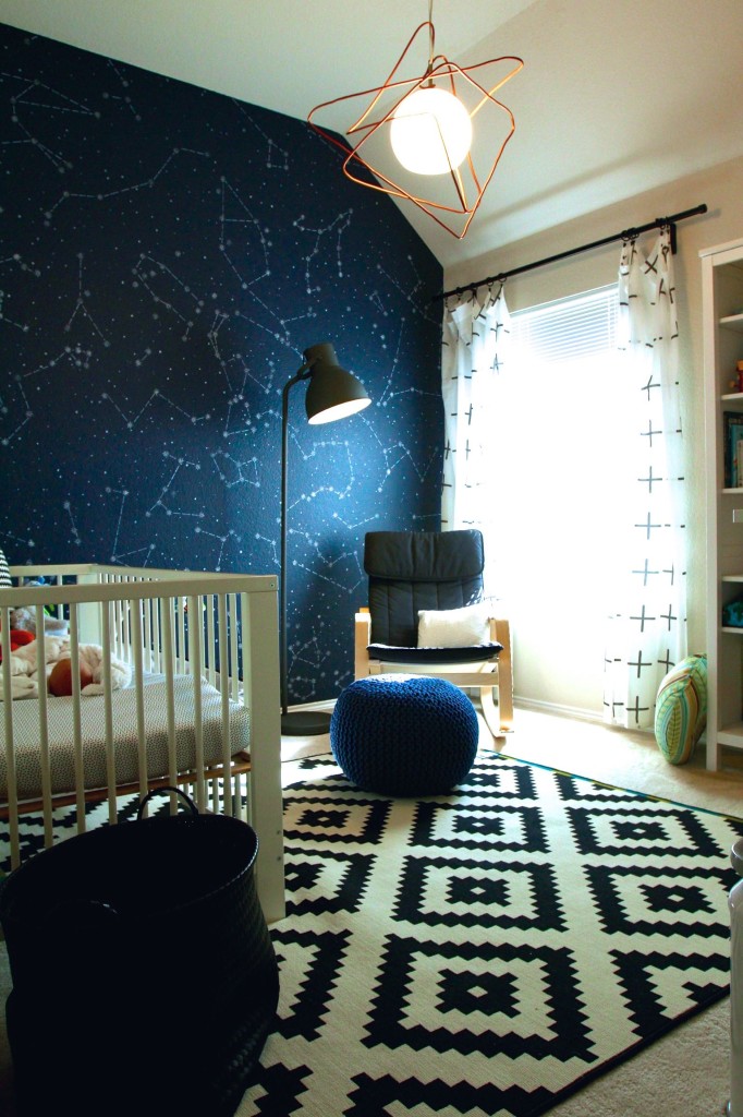 Space-themed nursery with white crib and space wallpaper.