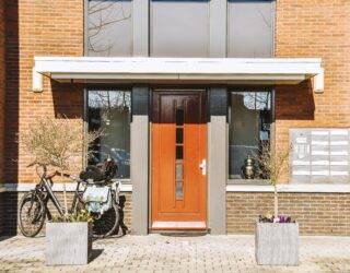 The front of a house with a terracotta door door.